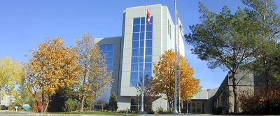 exterior of building that is tall with many glass windows and flags on flag poles in front