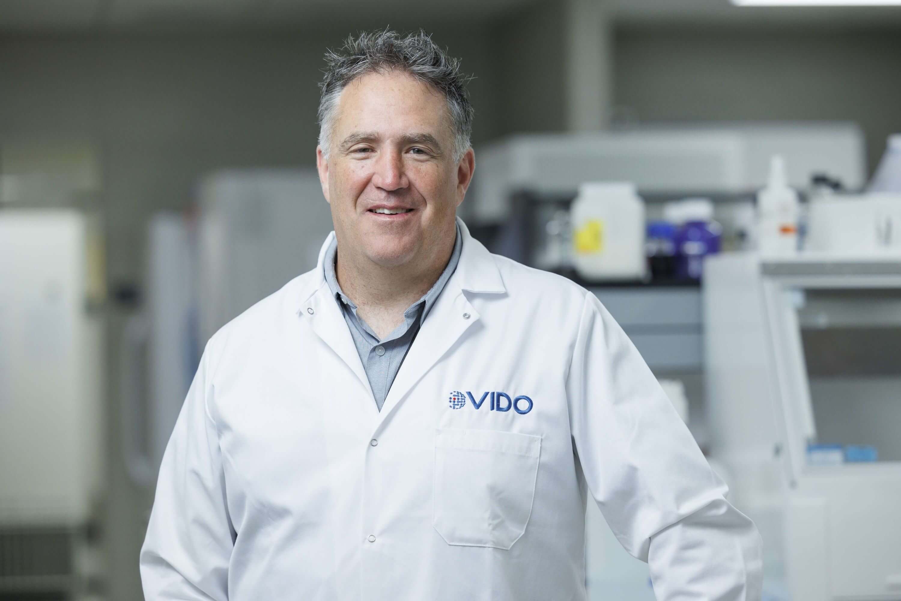 male scientist in lab coat looking at camera